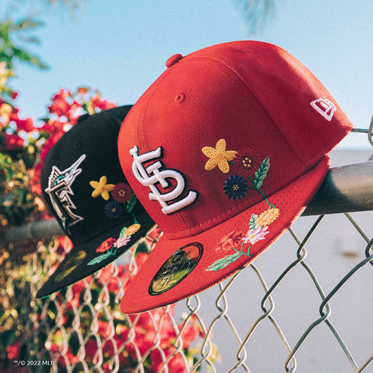 Florida Marlins and St. Louis Cardinals Visor Bloom hats on a chain link fence